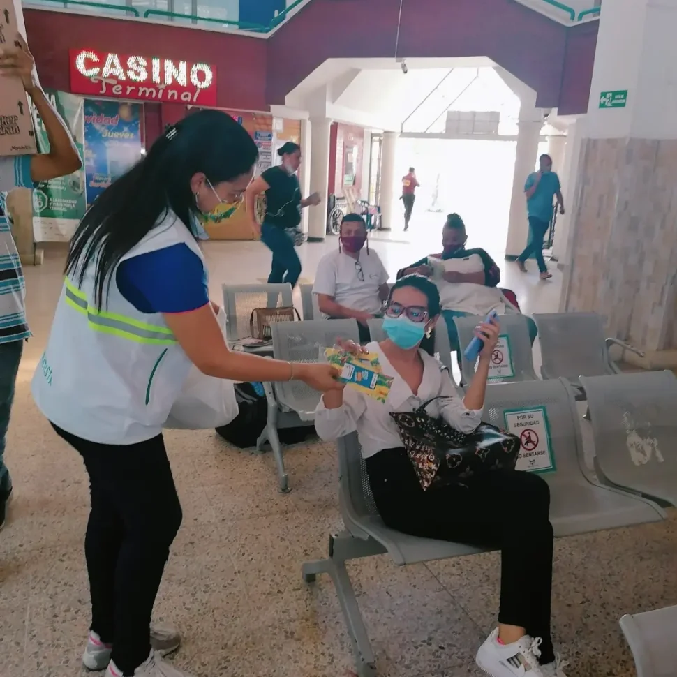 funcionaria de la Terminal haciendo entrega de volantes a los usuarios